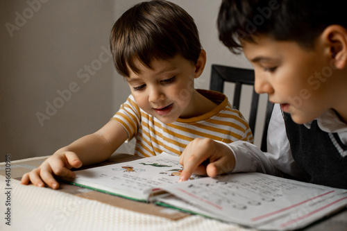 Schilderij op canvas the older brother teaches the younger to read