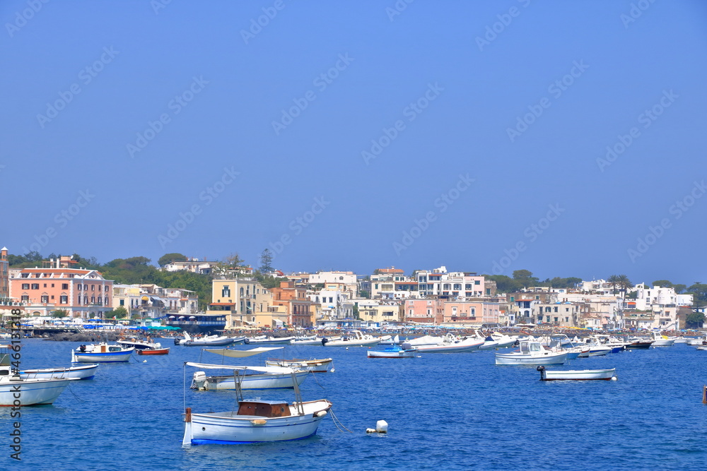 boats in front of the coast and beach in Ischia, Italy