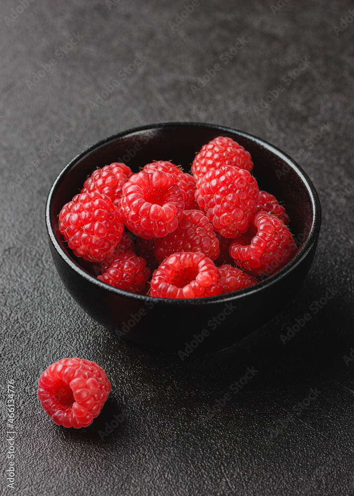 Raspberry in bowl on dark background. Raspberry in bowl on dark background.