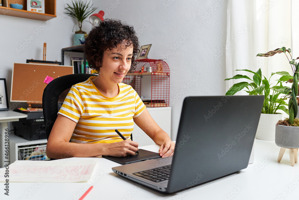 Graphic designer working from home with a graphic tablet and laptop Graphic designer working from home with a graphic tablet and laptop