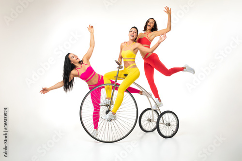 Sportswomen having fun on retro tricycle