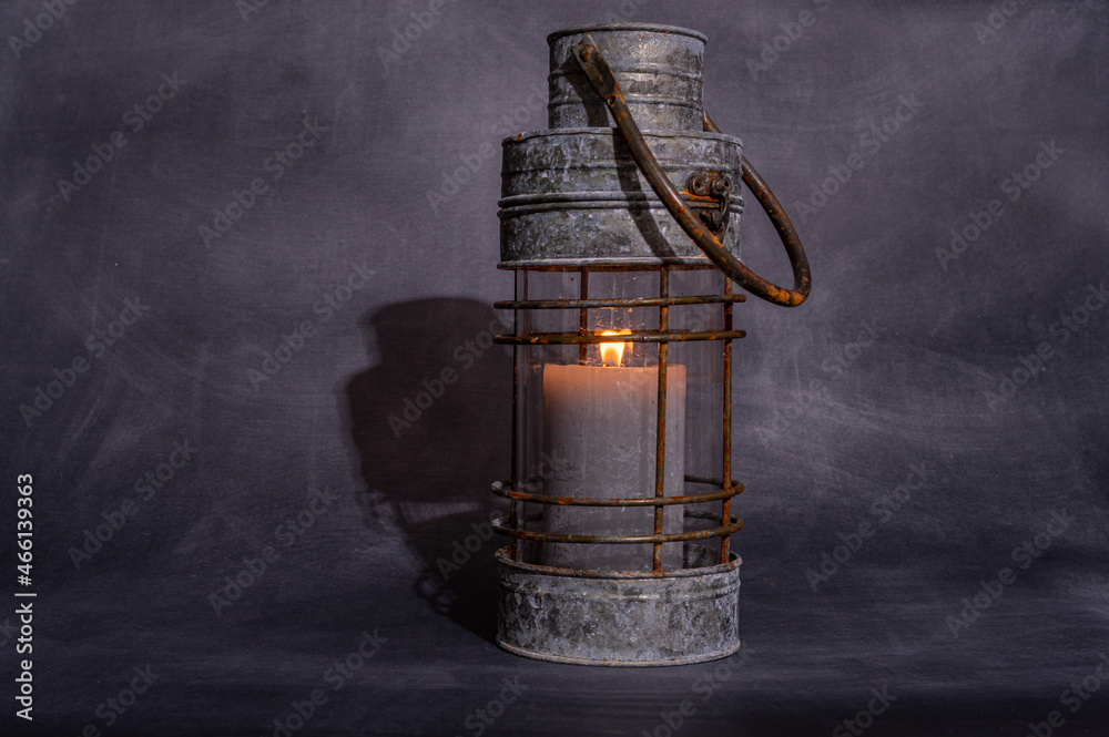 metalowa szara lampa ze świecą na szarym tle izolowana i minimalistyczna