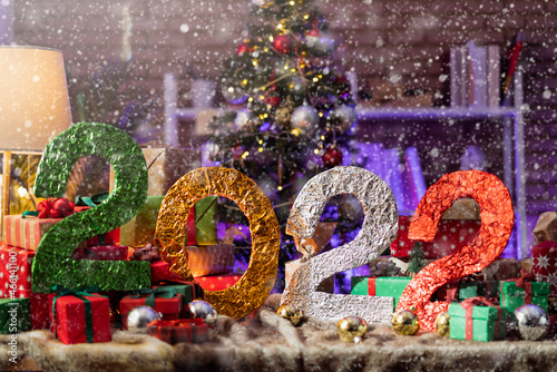 banner of 2022 christmas new year festive concept,presents gift ribbon boxes and decorative christmas tree with light bokeh arrange with composition on table,christmas festive background concept