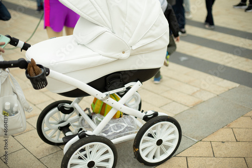 Children's stroller for walks. White cart for rolling the child.
