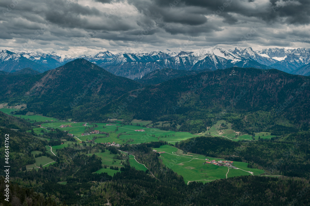 Fototapeta premium Snow covered Bavarian Alps with dramatic dark clouds, green forest at valley of Jachenau near Lake Walchensee, Bavaria.