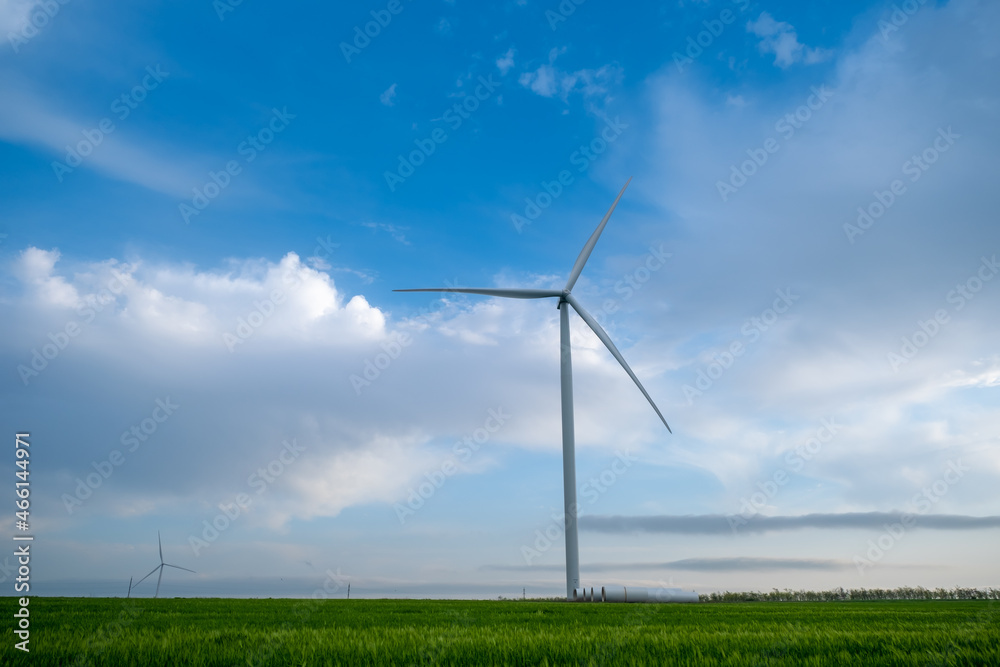 Wind power plant on agricultural field against the background of blue sky with clouds. Wind power plant on agricultural field against the background of blue sky with clouds.