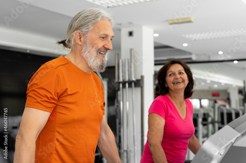 A beautiful elderly couple is working out together in the gym