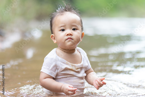 Baby kid sitting in water outdoor