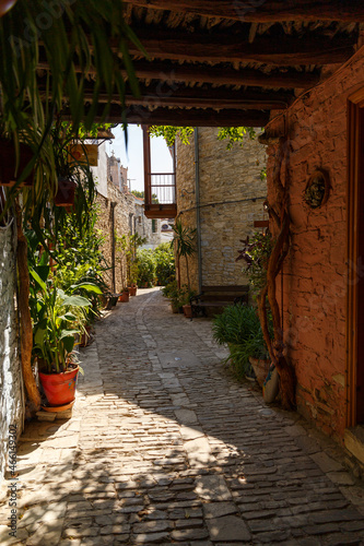 Beautiful narrow streets in an old mountain village. Pano Lefkara village, Cyprus. Street with flower pots and masonry. Stone exterior of old buildings with flowers on the streets