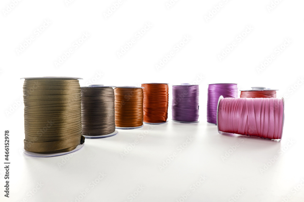 rolls with brown and red decorative ribbons of different shades for clothes on a white background rolls with brown and red decorative ribbons of different shades for clothes on a white background
