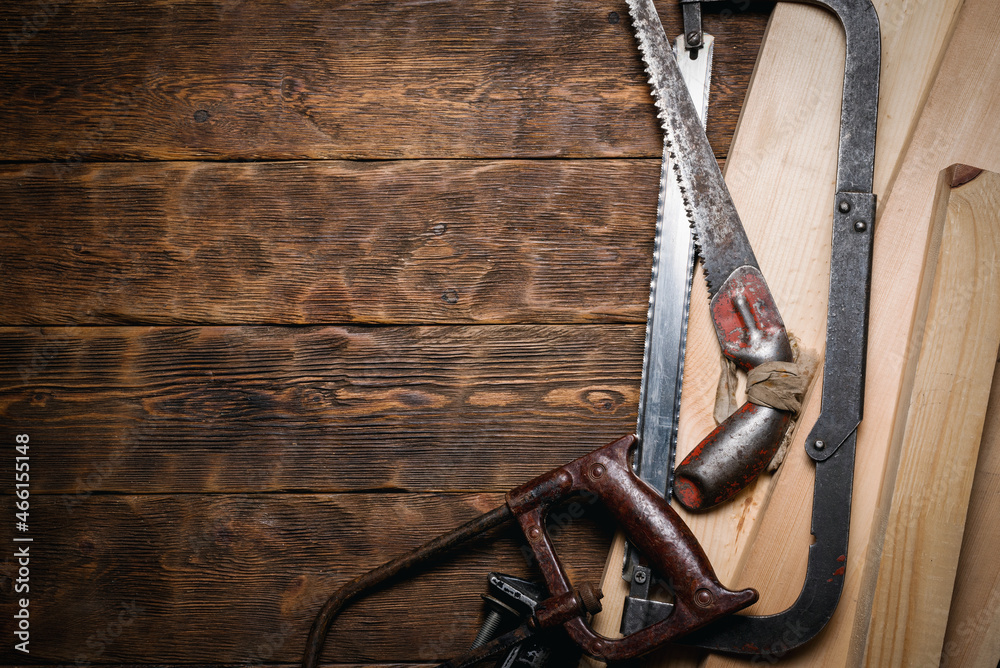 Saws and wooden bars on the carpenter flat lay workbench background with copy space.