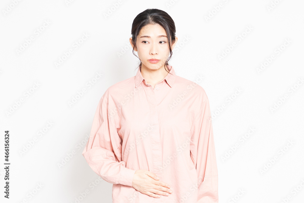 お腹を手で抑えている女性