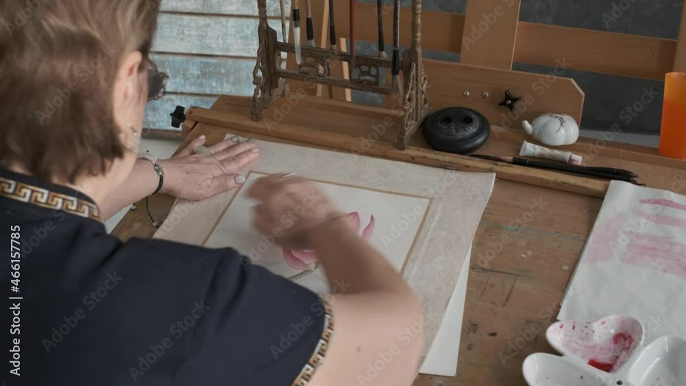 Senior Female Artist Attaching Passepartout to the Painting, Enjoying the Result. Creative Occupation and Artist workshop, Retirement Hobby Concept