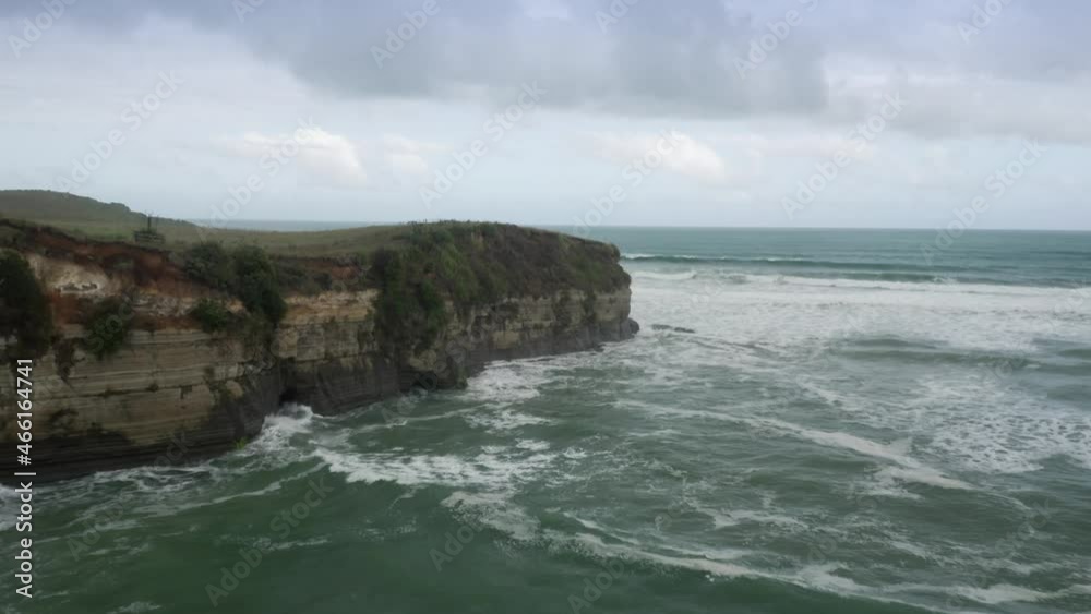 Aerial: Rocky Cliffs, crashing waves and farmland. Mokau, Taranaki, New Zealand Aerial: Rocky Cliffs, crashing waves and farmland. Mokau, Taranaki, New Zealand
