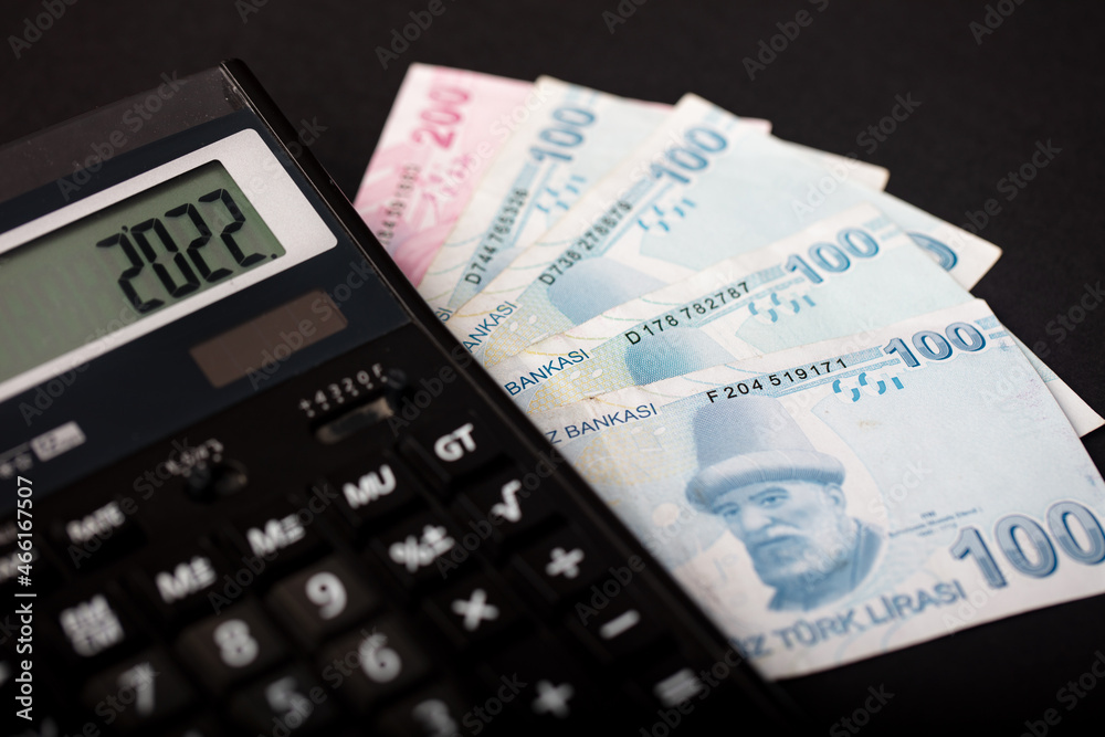 2022 with a calculator and Turkish lira banknotes, the concept of new year money, finance and budget in Turkey. 2022 with a calculator and Turkish lira banknotes, the concept of new year money, finance and budget in Turkey.