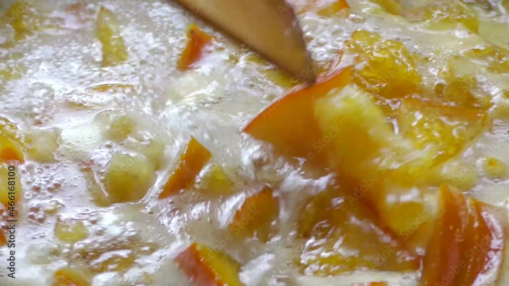 Orange jam is boiled and bubbled and stirred with a spatula Orange jam is boiled and bubbled and stirred with a spatula