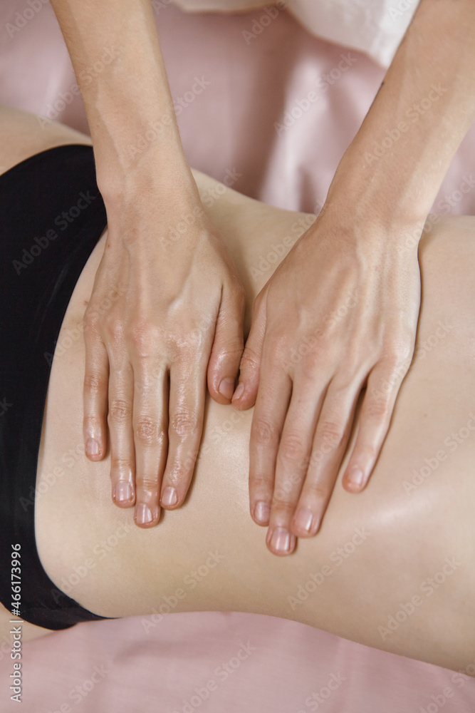 Close-up female masseur massages the stomach of the client while giving a massage of the intestines and abdominal area to a woman. Stomach and abdominal muscles relax procedure in salon Close-up female masseur massages the stomach of the client while giving a massage of the intestines and abdominal area to a woman. Stomach and abdominal muscles relax procedure in salon