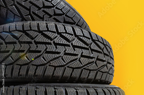 Winter car tires. Group of tires for winter driving on a yellow background.