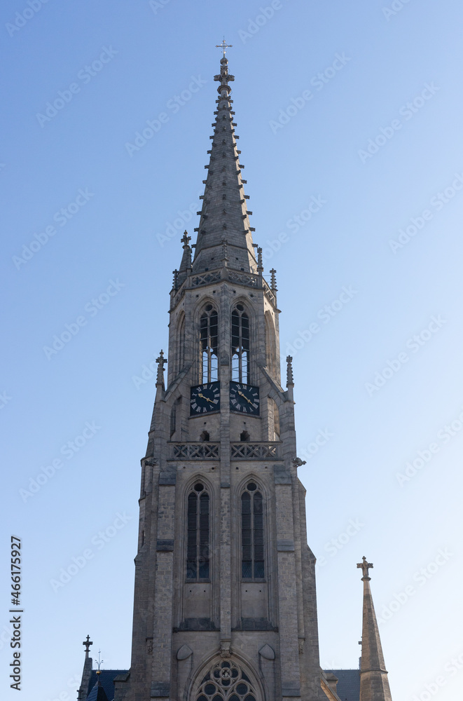 Wieża kościoła katolickiego na tle nieba.
