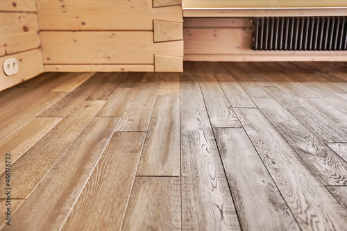 Close-up of natural wood parquet floor room with wooden walls in country house