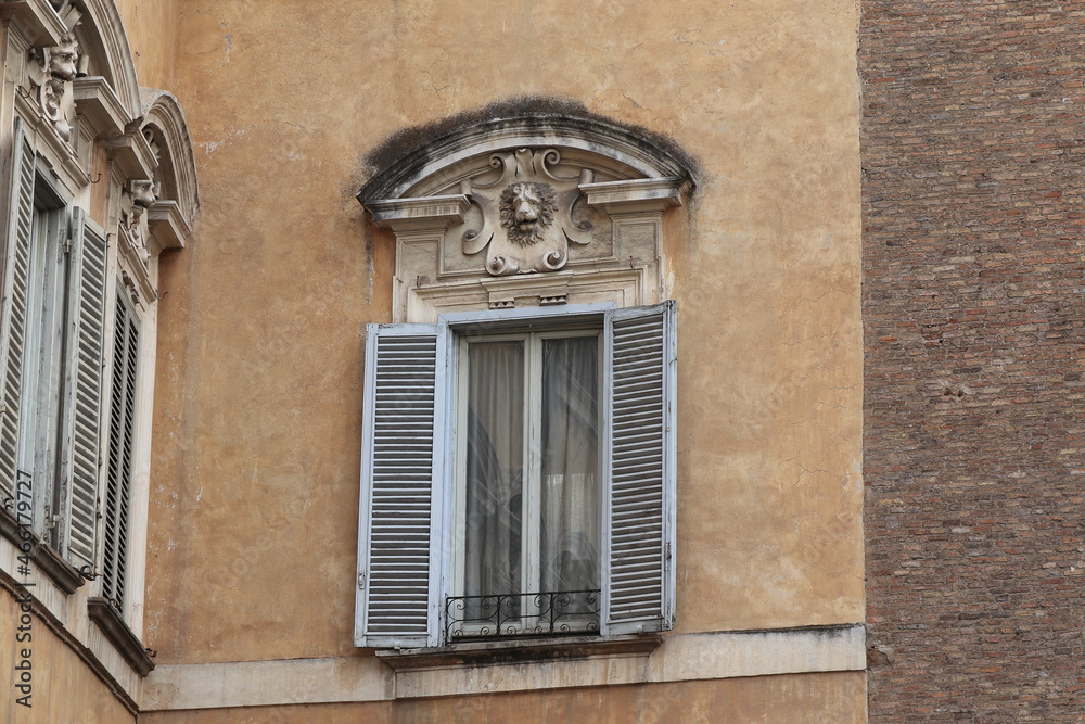 Obraz premium Window with Grey Shutters and Sculpted Lion Detail in the Monti District in Rome, Italy