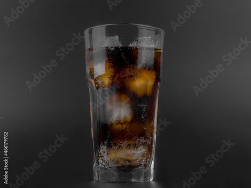 glass of cola with Ice Cubes on black background