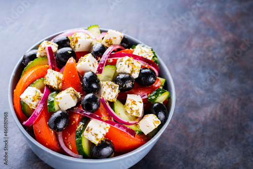Classic Greek salad with feta and olives on a dark background. Diet and healthy mediterranean salad. Copy space. Top view