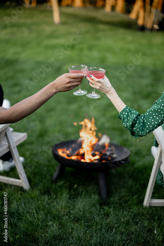 Photography Multiracial couple drinking cocktails during home party on a green lawn in their garden