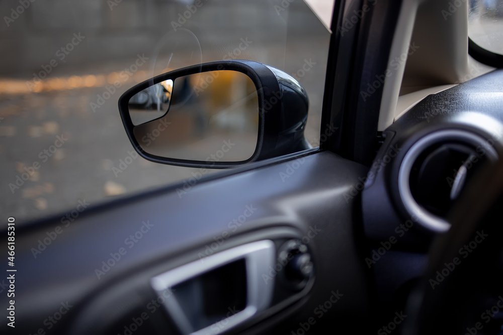 view from the interior of the car to the side mirror of the rear view of the car