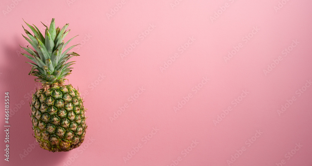 Pineapple placed on pale pink  flat-lay background