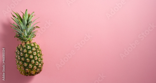 Pineapple placed on pale pink flat-lay background
