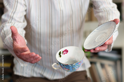 Obraz na plátně A man in stripy shirt dropping teacup, common accident, selective focus