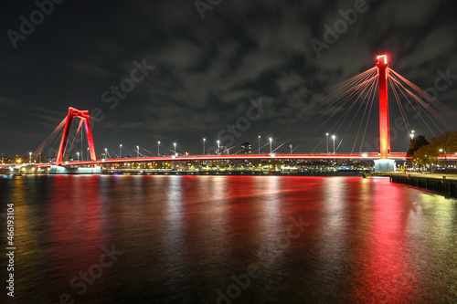 Red cable bridge in Rotterdam, Netherlands by night. Willemsbrug bridge in Rotterdam, Holland. Modern architecture and cityscape. Landmark. photo