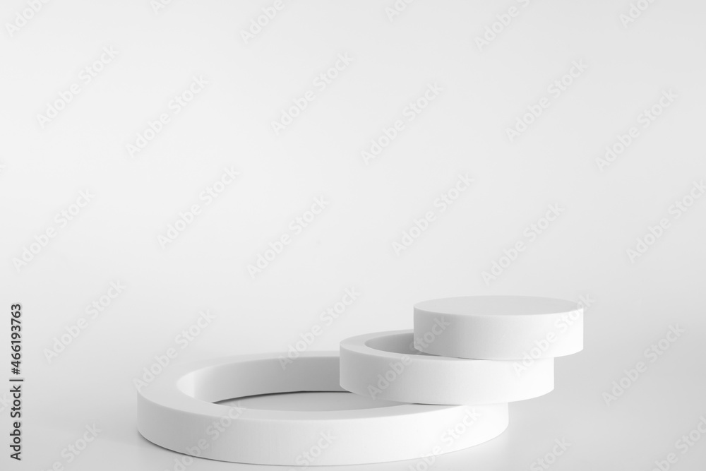 White podium on the white background, simple geometric forms. Podium for product, cosmetic presentation. Creative mock up. Pedestal or platform for beauty products.