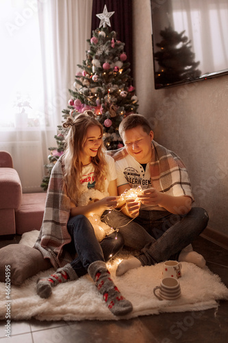Couple sitting near the christmas tree © Angelina Kosova