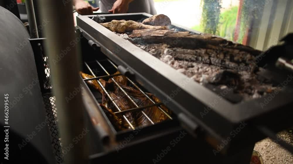 video de 2 personas utilizando una caja china para cocinar un animal 