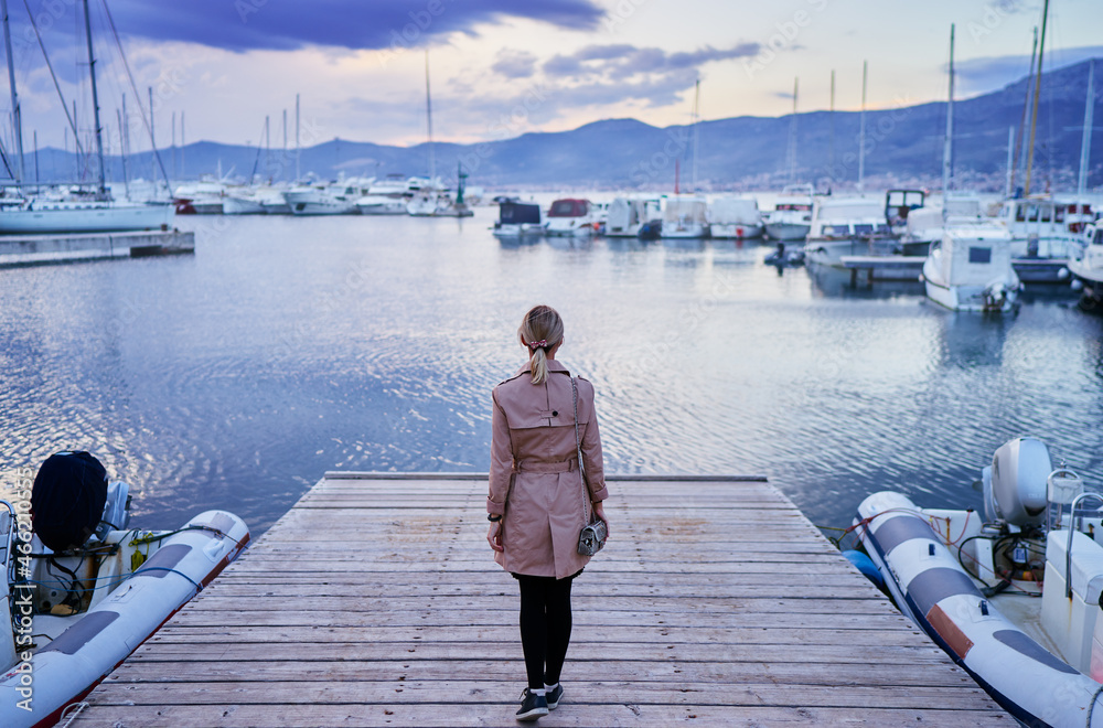 Tourism concept. Young traveling woman enjoying the view at sea marina. Tourism concept. Young traveling woman enjoying the view at sea marina.
