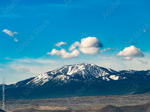 Snow covered Slide Mountain or Mt. Rose, south of Reno, Nevada with a rich blue sky and white puffy clouds.