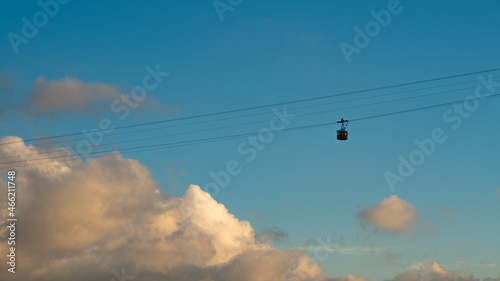 Overhead cable car on sunset. Trolley silhouette. Cloudy sky sunset.