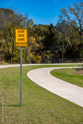 Curved Path With a Yellow Warning Sign About Flooding