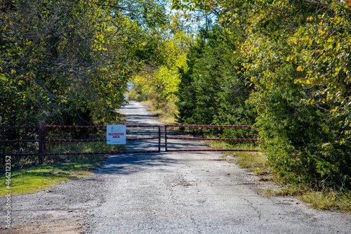 Restricted Access Sign on a Gate Blocking a Park Road