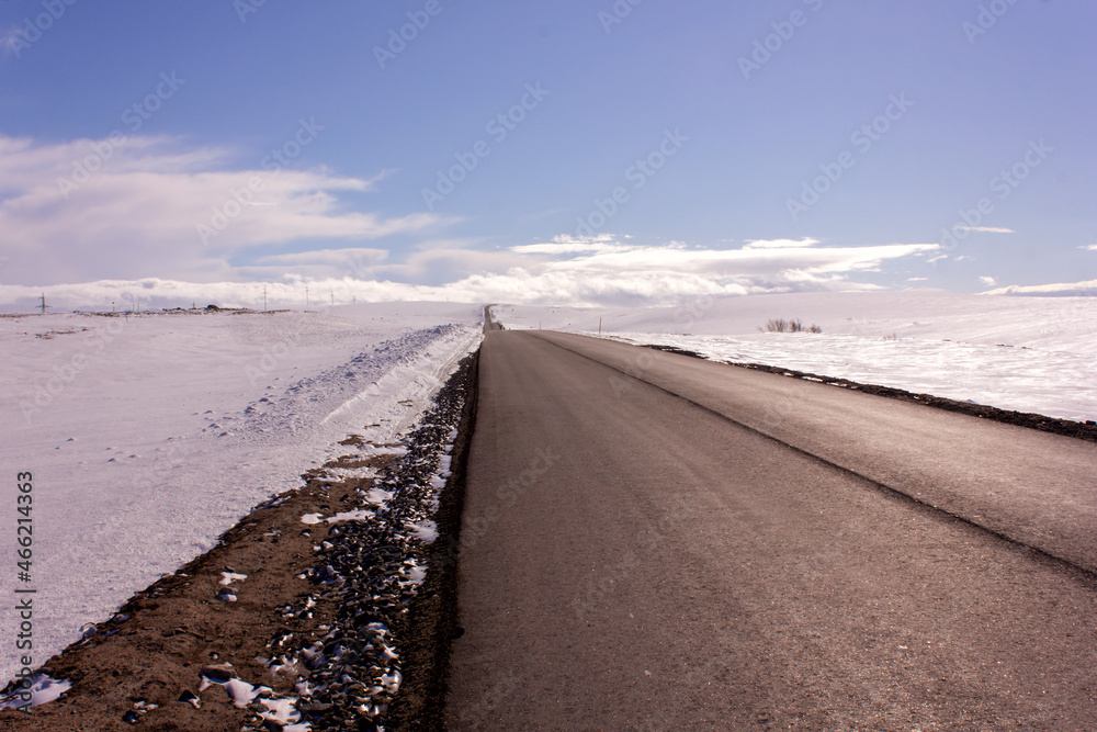 motor road highway passes through a snowy valley in perspective goes into the horizon motor road highway passes through a snowy valley in perspective goes into the horizon