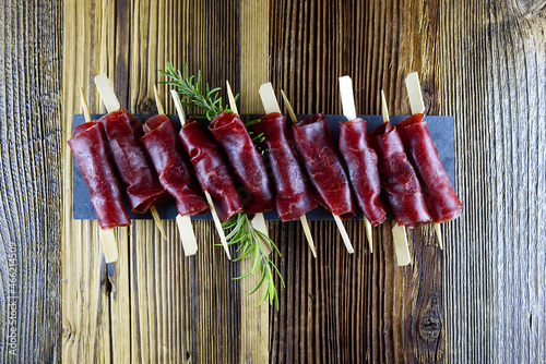 Top view of aperitif from dried meat on wooden background