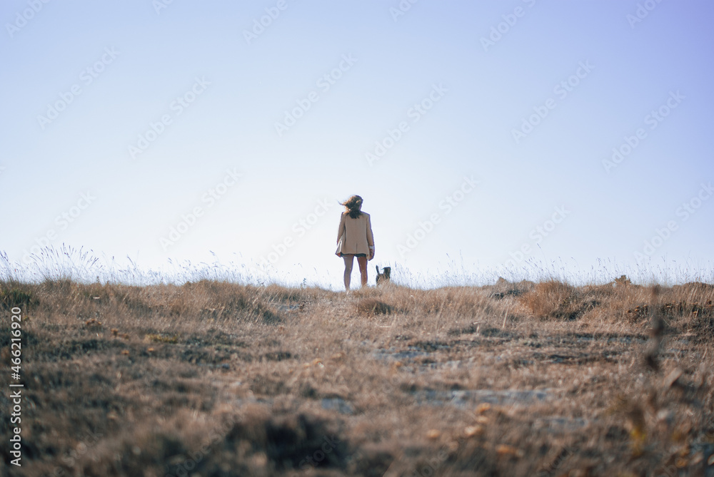Obraz premium Women standing at a field with a dog