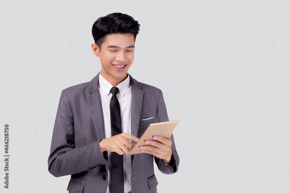 Portrait young asian business man in suit standing using tablet computer to internet isolated on white background, businessman confident touch screen digital pad with success, communication concept. Portrait young asian business man in suit standing using tablet computer to internet isolated on white background, businessman confident touch screen digital pad with success, communication concept.