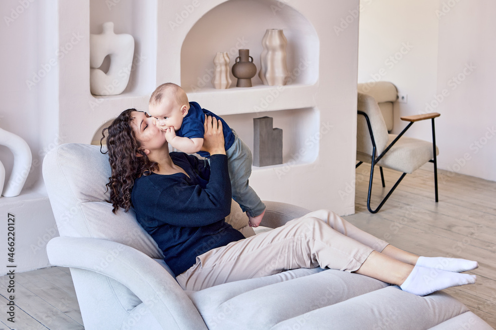 Obraz premium Woman spends time with infant on sofa in living room.