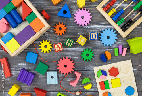 Multicolored fractions, blocks, toys on a gray wooden table. Back to school, fun math, games for kindergarten, preschool education.
