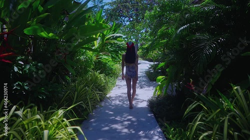 Back View Girl In Swimming Suit Walking Alone In Resort on Sunny Day Slow Motion