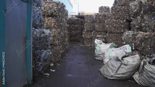 Bundle of pressed plastic bottles prepared for a garbage recycling on waste recycling plant. Camera moves to the side. Pollution problem. Stabilized video