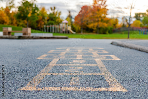 Schoolyard and playground for elementary students in evening in autumn season. Selective focus on hopscotch. Back to school or kindergarten educational concept.